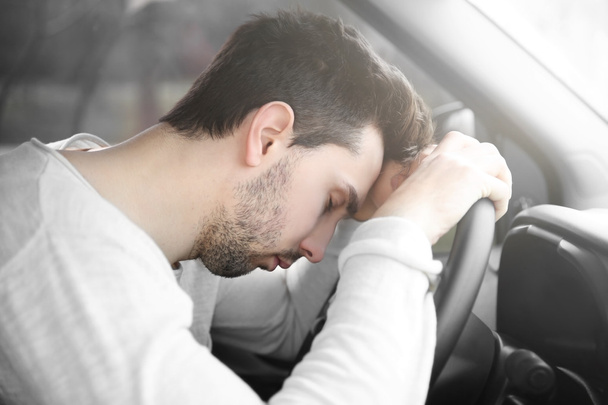 Tired young man asleep in car. - Фото, изображение
