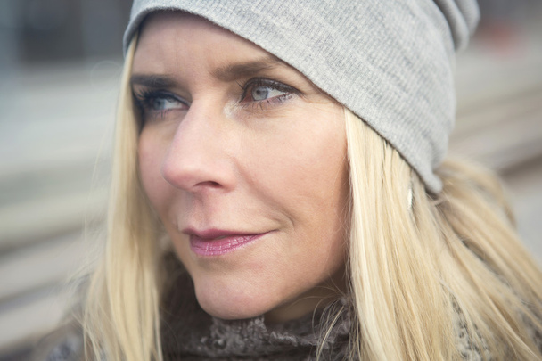 portrait fo a blond woman outdoors wearing a cap - Photo, image