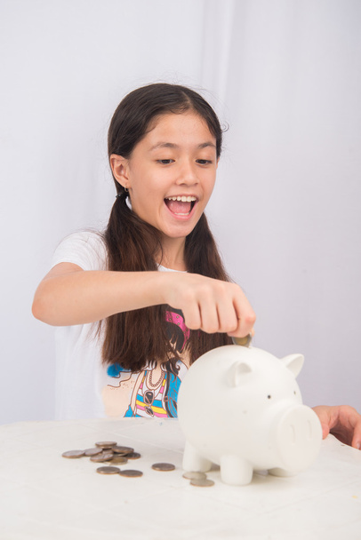 Little girl saving money in piggy bank - Photo, Image