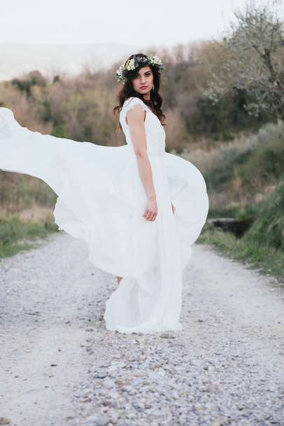 portrait of bohemian bride in nature, with white dress and crown - Foto, Imagem