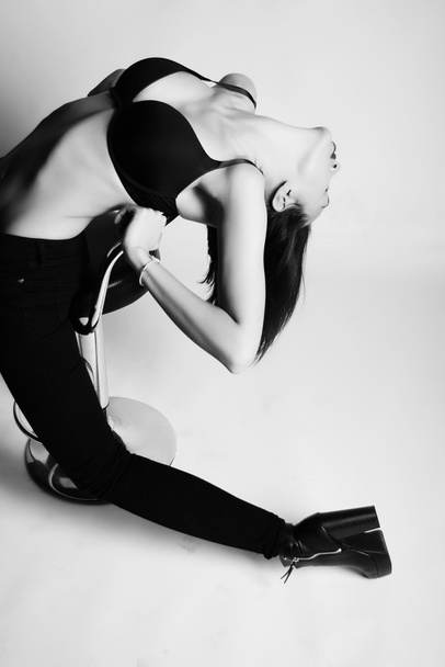 Brunette seksikäs hoikka nainen tanssii barchair lattialla pitkä valkoinen paita ja korkokengät
 - Valokuva, kuva