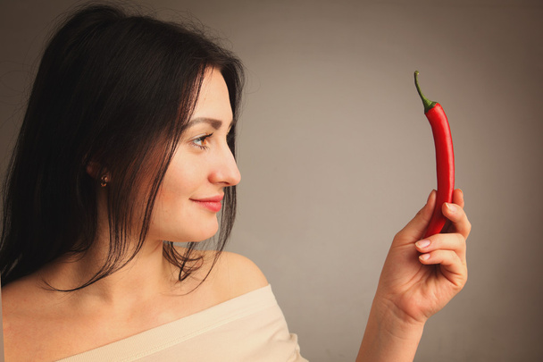 πορτρέτο όμορφη γυναίκα με κόκκινο καυτό πιπέρι τσίλι - Φωτογραφία, εικόνα