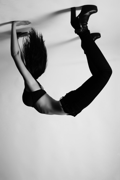 Brunette in bridge pose upside down, wearing bra and high heels - Photo, Image