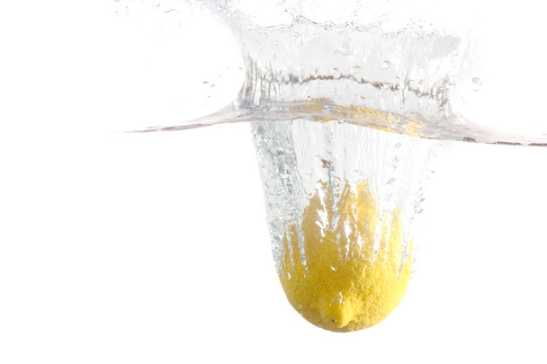 Fresh lemon dropped into water with splash isolated on white - Foto, Imagem