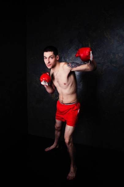 Boxer avec gants rouges dans la chambre noire
 - Photo, image