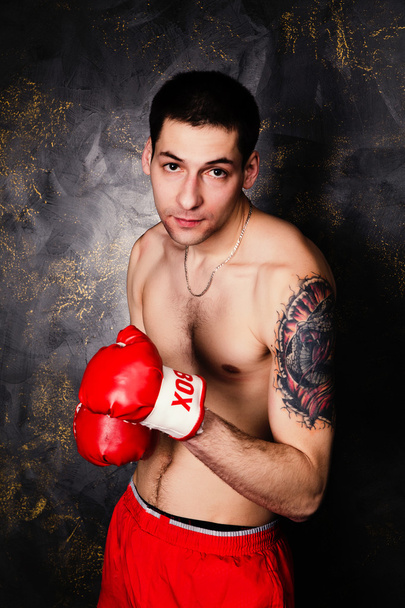 Boxeador con guantes rojos en habitación oscura
 - Foto, Imagen