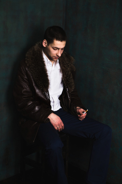 hombre guapo en asiento abrigo de piel en la esquina y pensar
 - Foto, imagen
