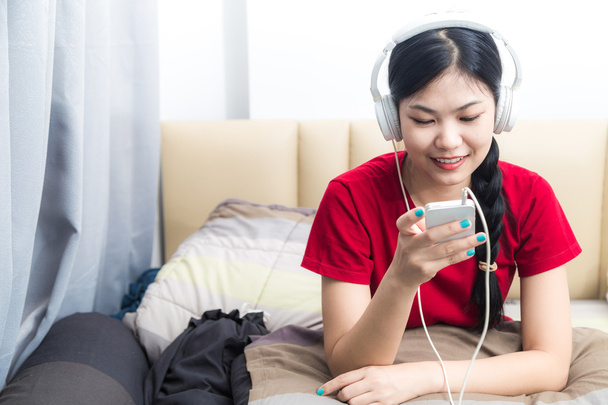 attraktive asiatische Frau Musik hören auf Bett lächeln - Foto, Bild