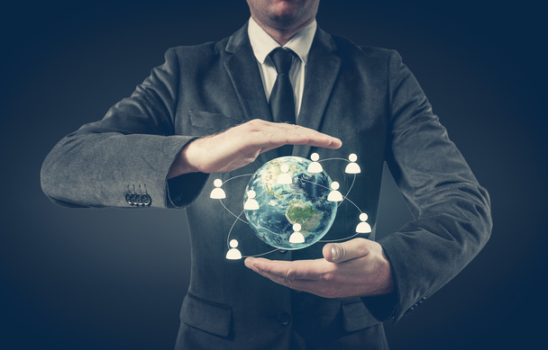 Бізнесмен тримає глобус у руках. Концепція управління персоналом по всьому світу
 - Фото, зображення