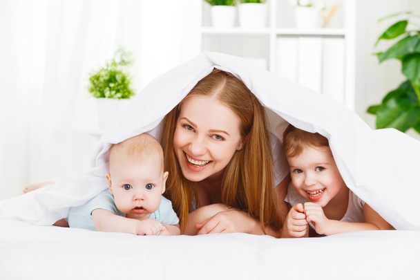 gelukkige familie moeder en twee kinderen, zoon en dochter in bed VN - Foto, afbeelding