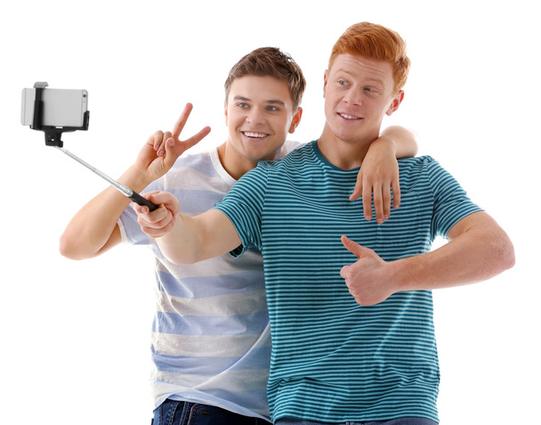 Two teenager boys making photo by their self with mobile phone - Foto, afbeelding