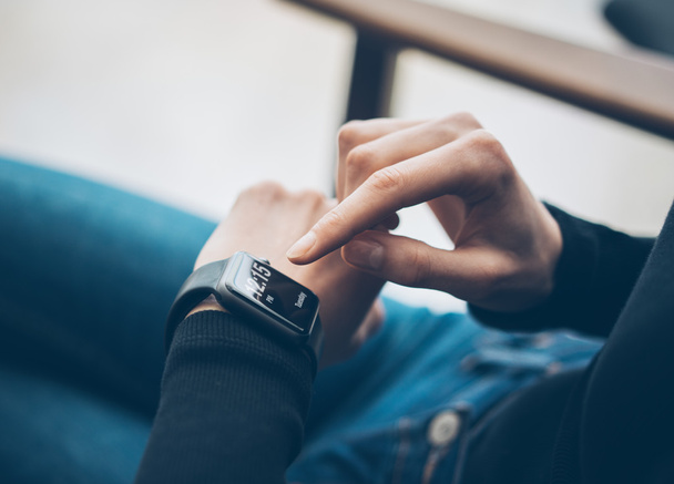 Closeup photo of female hand touching screen generic design smart watch. Film effects, blurred background. Horizontal - Foto, immagini
