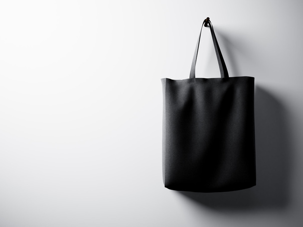 Photo black cotton textile bag hanging right side. Empty white wall background. Highly detailed texture, space for business message.  Horizontal. 3d render - Foto, immagini