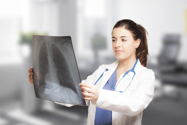 Valkoihoinen naislääkäri katselee radiografiaa
 - Valokuva, kuva