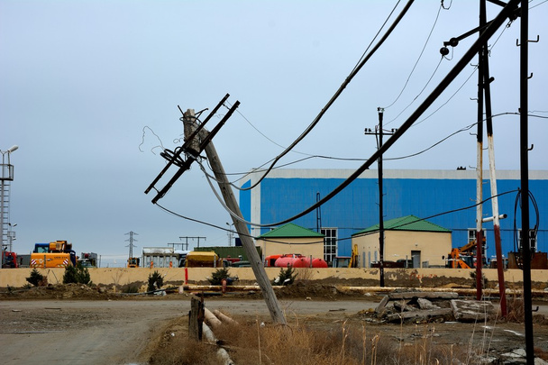 Scheve telegraph pole in industriële rand van Bakoe, de hoofdstad van Azerbeidzjan - Foto, afbeelding