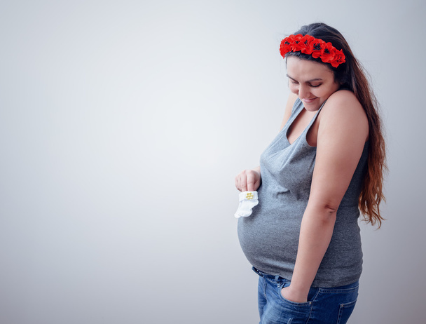 Kobieta w ciąży trzyma skarpetki dla dzieci - Zdjęcie, obraz