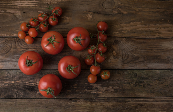 Tomates frescos y maduros sobre un viejo jabalí de madera
 - Foto, imagen