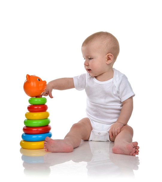 Infant child baby boy toddler playing with Pyramid in hand on a  - Фото, изображение
