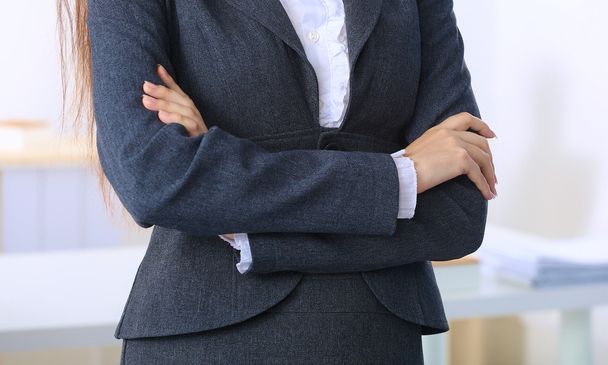 Портрет деловой женщины, стоящей со скрещенными руками в кабинете - Фото, изображение