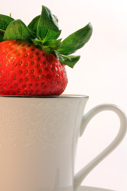 Fresas rojas frescas dentro de una taza de té blanca de China
 - Foto, imagen