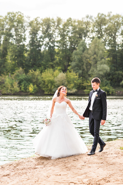 Wedding couple walking  near lake. - Фото, зображення