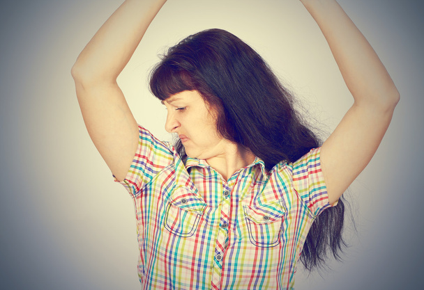 young woman, smelling, sniffing her armpit - Photo, Image