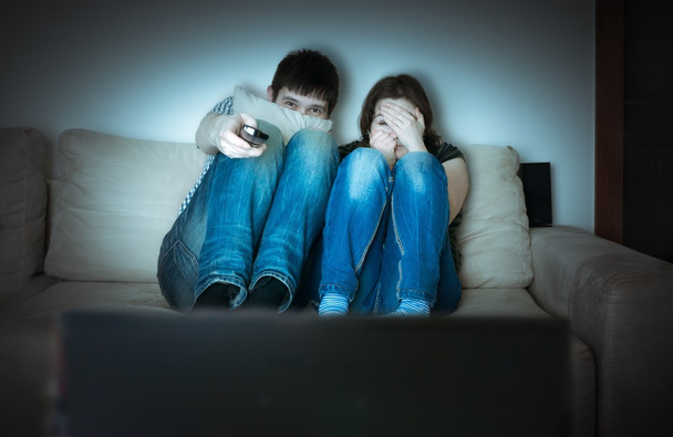 Giovane coppia spaventata sta guardando orrore in TV
. - Foto, immagini