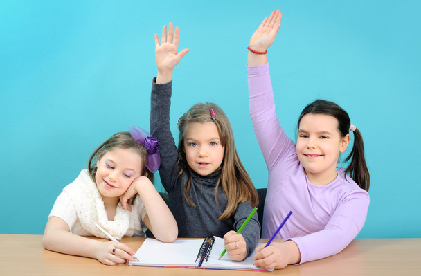 Три счастливые девочки делают свою школьную работу
 - Фото, изображение