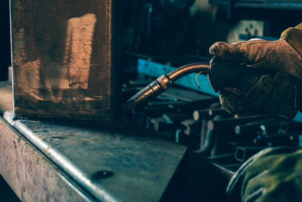 Hand of welder holding welding device - Фото, зображення