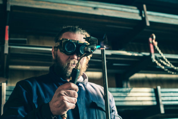 Man with goggles soldering iron pipe - Photo, Image