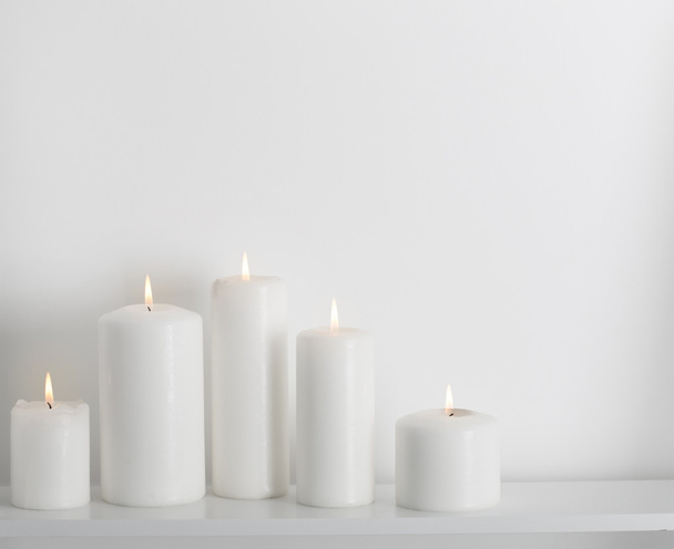 bougies blanches brûlant sur une étagère blanche
 - Photo, image