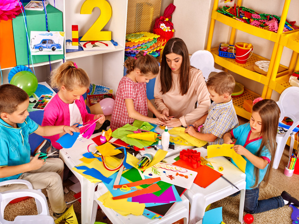 Children with teacher woman painting on paper in  kindergarten . - Photo, Image