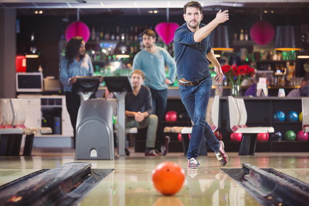 Group of friends playing in bowling alley - Фото, изображение