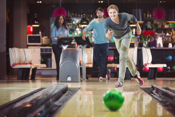 Lachende gelukkig man is het gooien van de bowlingball - Foto, afbeelding