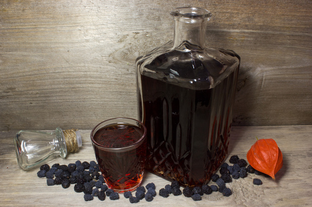 Glas und Karaffe mit rotem alkoholischen Getränk - Foto, Bild