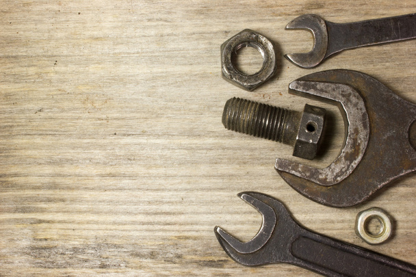Wrench, nuts and bolts on wooden background - Photo, Image