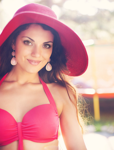 Modieuze vrouw in rode hoed poseren in een rode bikini - Foto, afbeelding