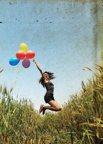 Giovane donna con palloncini colorati nel campo
 - Foto, immagini