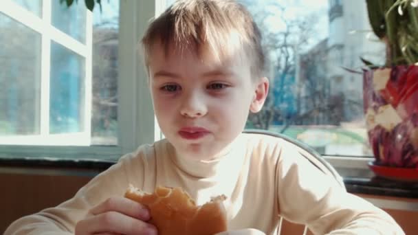 Αγόρι που τρώει χάμπουργκερ στο εστιατόριο Φάστ φούντ - Πλάνα, βίντεο