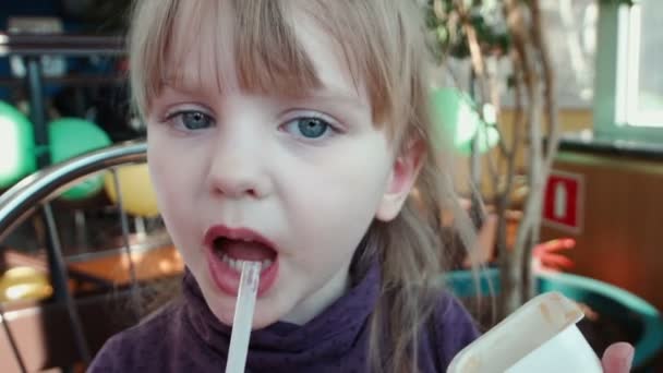das kleine Mädchen trinkt Cocktail und leckt Sauce - Filmmaterial, Video