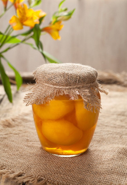 Скляна банка зі стиглим персиковим компотом натуральна вегетаріанська десертна їжа
 - Фото, зображення