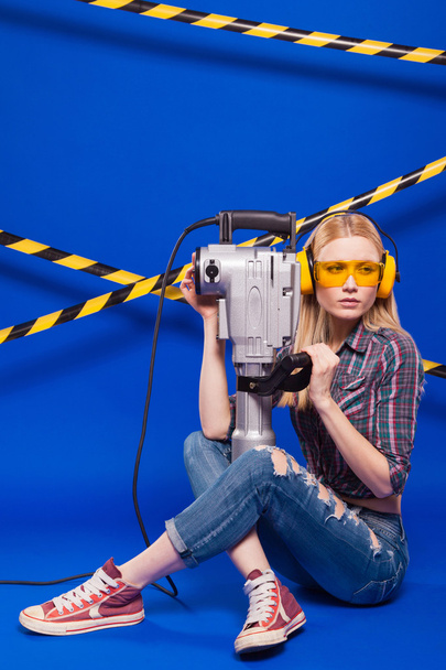 Tvůrce dívka na modrém pozadí s profesionální stavební nástroj v ochranné přilbě - Fotografie, Obrázek