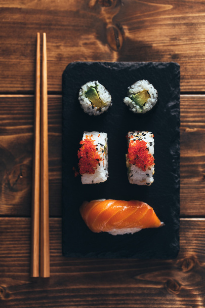 Maki sushi on a wooden table. Top view - Foto, afbeelding