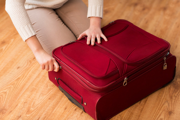 close up of woman packing travel bag for vacation - Valokuva, kuva