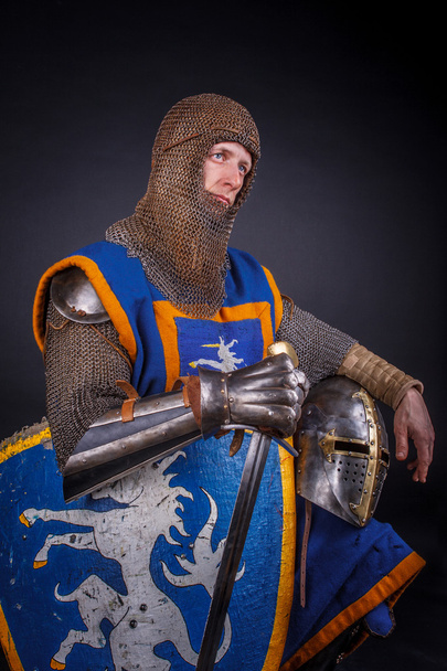 A knight with a sword and helmet - Фото, изображение