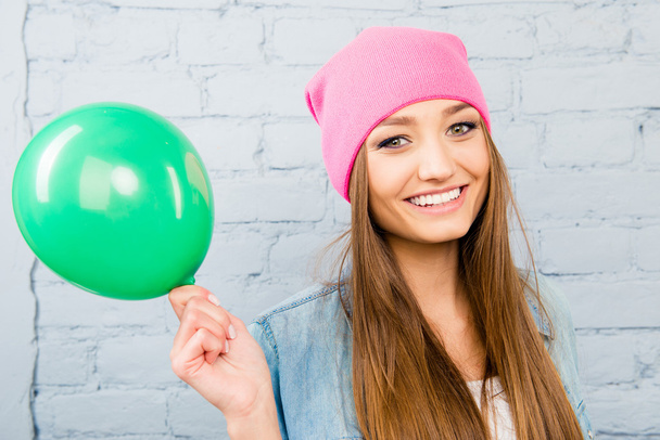 Portrait of attractive hipster girl in pink hat holding balloon - Foto, immagini
