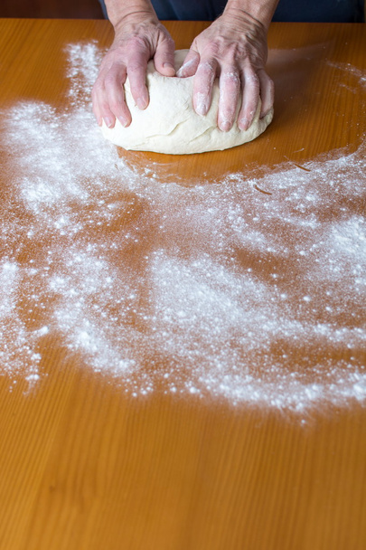 Handen van een mannelijke Bakker brood maken - Foto, afbeelding