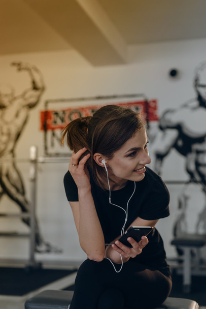 Beautiful girl at the gym listening to music - Foto, Imagem