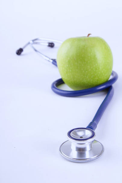 Medical stethoscope and apple isolated on white background - Фото, зображення