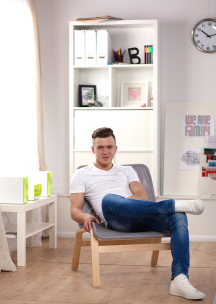 Virassa työskentelevä nuori liikemies, istuu pöydän ääressä - Valokuva, kuva